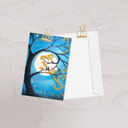 A greeting card with a full moon and two cats design.