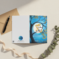 A greeting card with a full moon and two cats design.