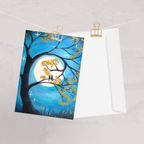 A greeting card with a full moon and two cats design.