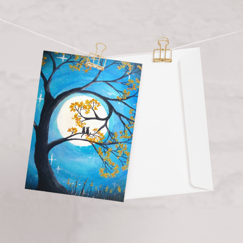 A greeting card with a full moon and two cats design.