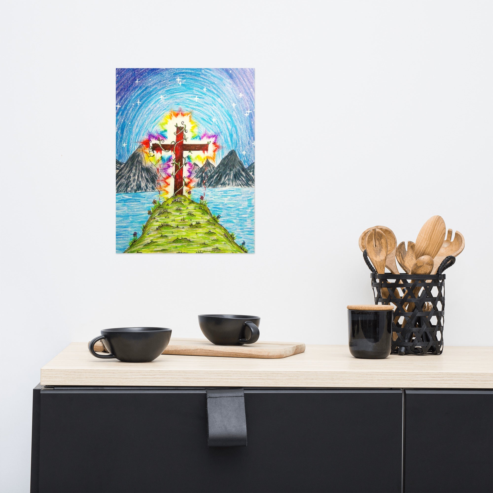 Colorful abstract painting of a cross on a mountain above water, displayed on a wall above a kitchen counter.