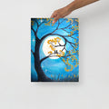 Painting of a tree with yellow leaves and a full moon, held by a hand on a white background.