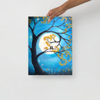 Painting of a tree with yellow leaves and a full moon, held by a hand on a white background.