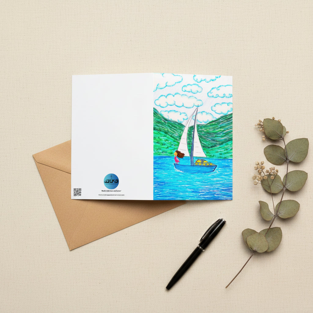 A rectangular greeting card, featuring a colourful illustration of a sailboat on blue water with green hills and white clouds. The left side of the card is plain white with the AllThingsGoode logo.
