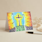 A white rectangular greeting card featuring a colourful illustration of Jesus' sacrifice with a radiant blue, yellow, and orange glow.